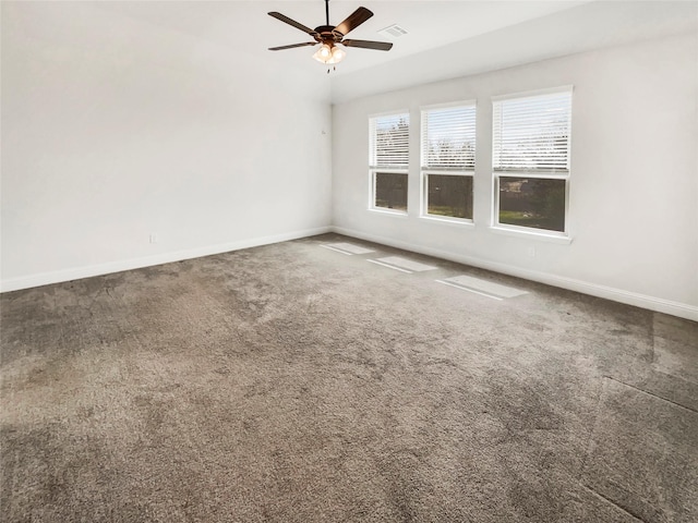 carpeted spare room featuring visible vents, a ceiling fan, and baseboards