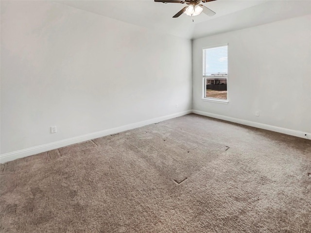 carpeted empty room with vaulted ceiling, baseboards, and ceiling fan