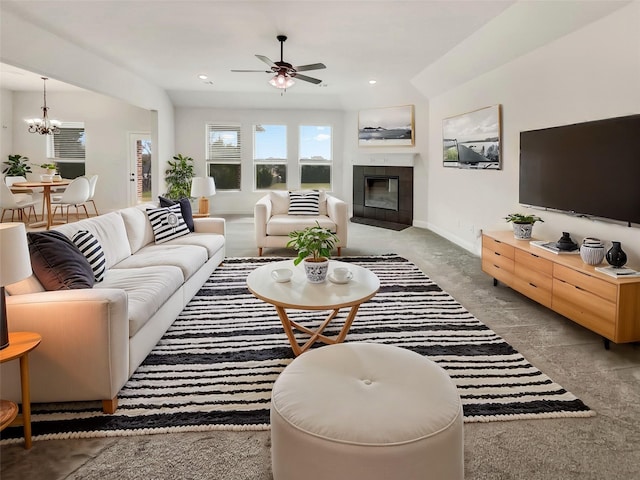 living room featuring recessed lighting, baseboards, a fireplace, and ceiling fan with notable chandelier