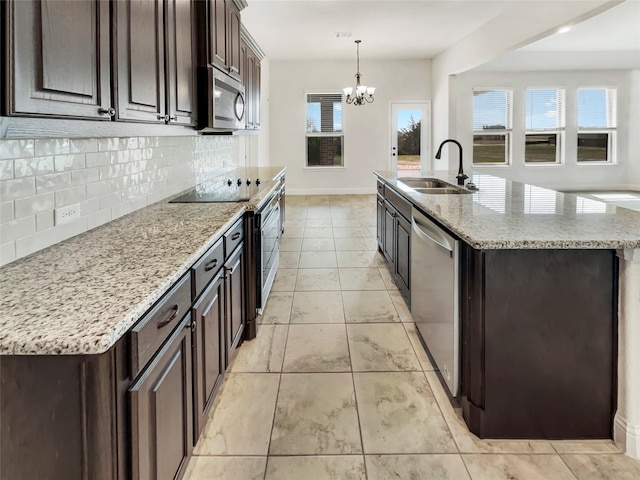 kitchen with a sink, decorative backsplash, appliances with stainless steel finishes, and dark brown cabinets