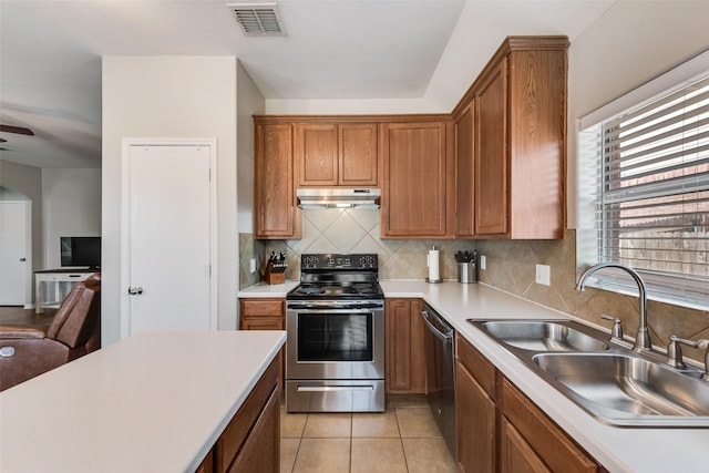 kitchen with visible vents, a sink, under cabinet range hood, appliances with stainless steel finishes, and backsplash