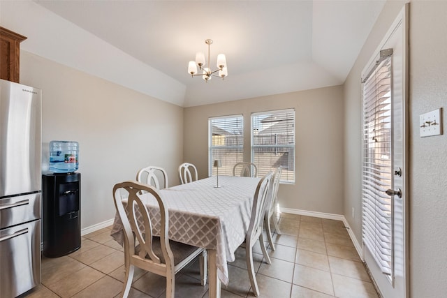 dining space with light tile patterned floors, baseboards, lofted ceiling, and a chandelier