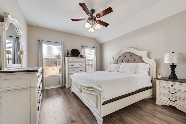 bedroom with dark wood-style floors, ceiling fan, baseboards, and lofted ceiling