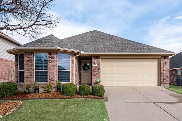 ranch-style home featuring roof with shingles, an attached garage, concrete driveway, a front lawn, and brick siding