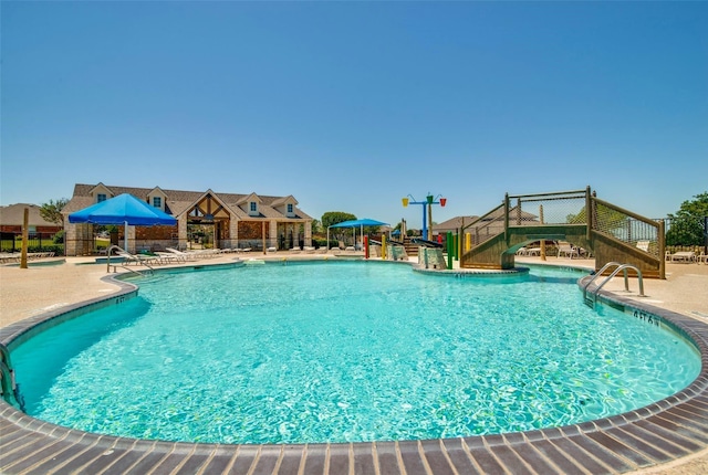 pool with a patio and a water play area