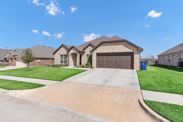 french country home with brick siding, a garage, concrete driveway, and a front yard