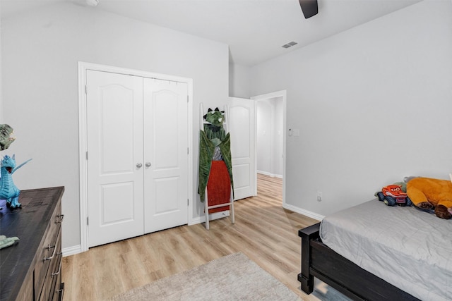 bedroom with a ceiling fan, baseboards, visible vents, light wood finished floors, and a closet