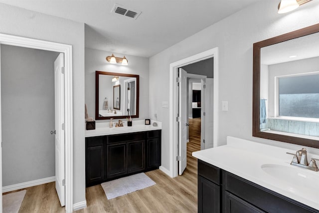 bathroom featuring visible vents, wood finished floors, and a sink