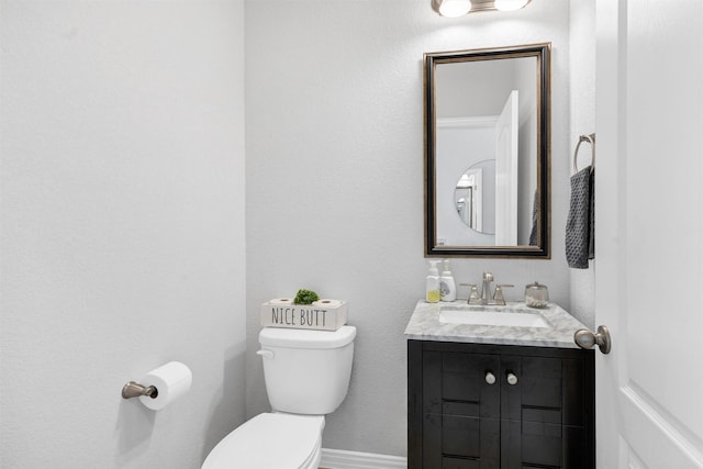 bathroom featuring vanity, toilet, and baseboards