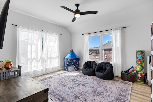 sitting room with vaulted ceiling, wood finished floors, a wealth of natural light, and ceiling fan