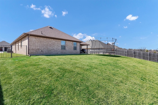 view of yard with a trampoline and fence