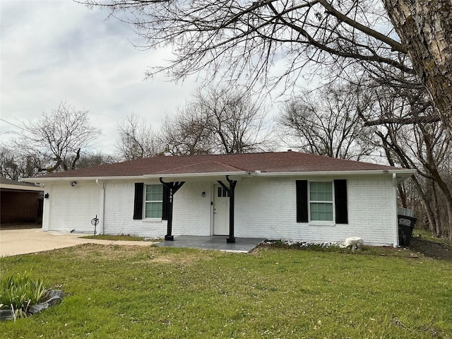 single story home featuring a porch, concrete driveway, a front yard, an attached garage, and brick siding