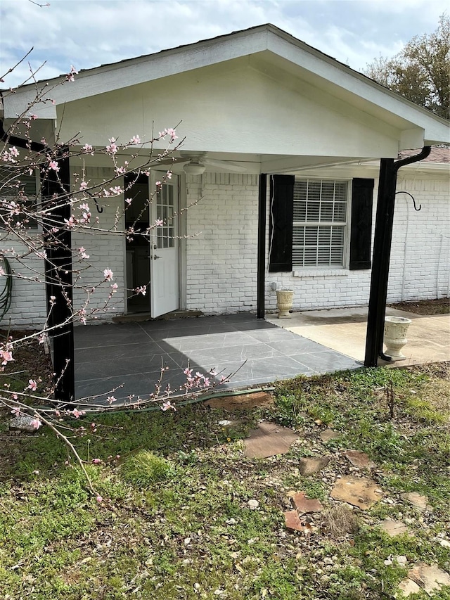 back of property with brick siding and a porch