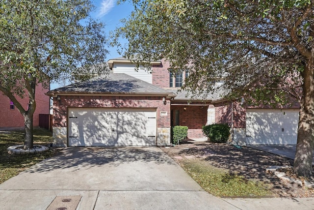 view of front of house with an attached garage, brick siding, and driveway