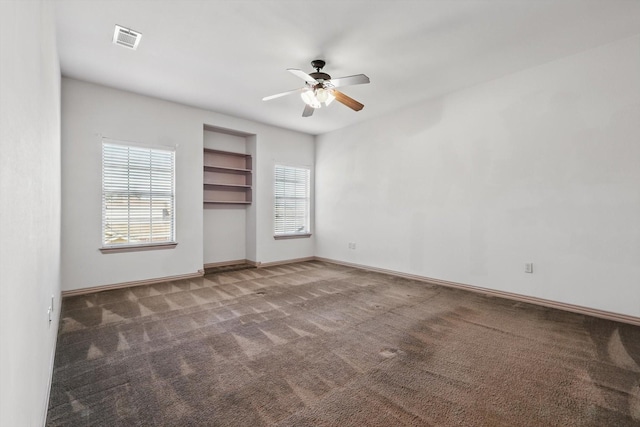 carpeted spare room with a ceiling fan, visible vents, and baseboards