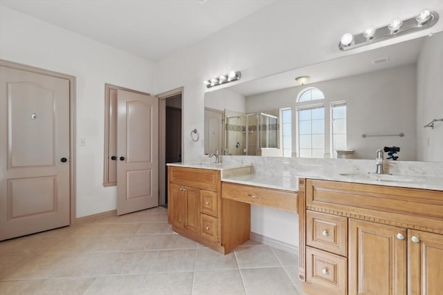 bathroom featuring double vanity, a stall shower, tile patterned floors, and a sink