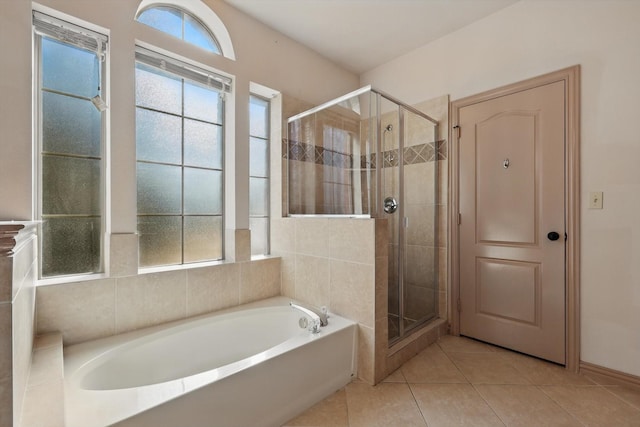 full bath featuring tile patterned flooring, a shower stall, and a garden tub