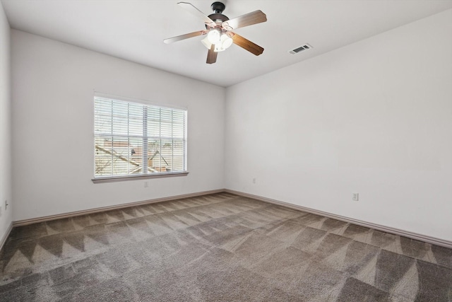 empty room with baseboards, carpet, visible vents, and ceiling fan