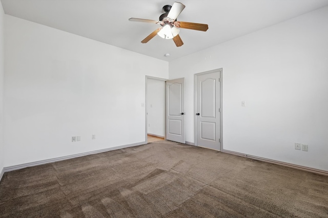 carpeted spare room with a ceiling fan