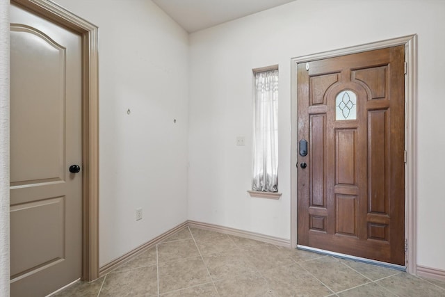 foyer featuring light tile patterned flooring and baseboards