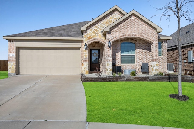 french country home featuring brick siding, a front lawn, concrete driveway, a garage, and stone siding