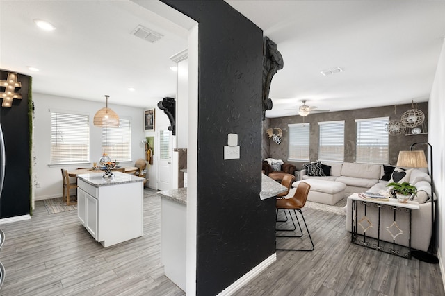 kitchen featuring visible vents, white cabinets, and light wood-type flooring