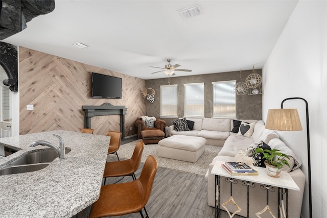 living area featuring a ceiling fan, wood finished floors, and visible vents