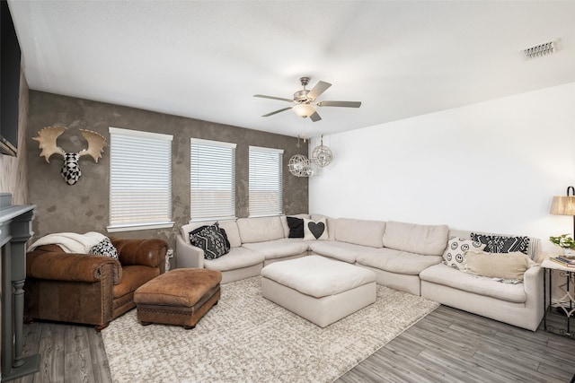 living area with wood finished floors, visible vents, and ceiling fan