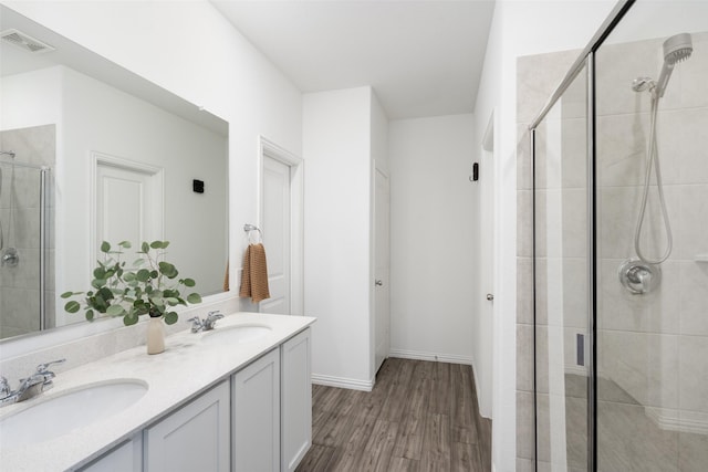 full bathroom with a shower stall, double vanity, visible vents, and a sink