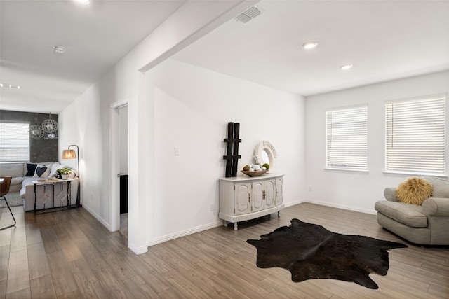 living area featuring a healthy amount of sunlight, baseboards, and wood finished floors