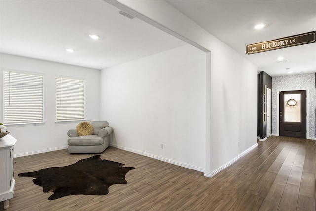 living area with recessed lighting, visible vents, baseboards, and wood finished floors