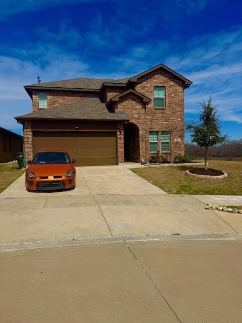 traditional-style house with brick siding, concrete driveway, and a garage