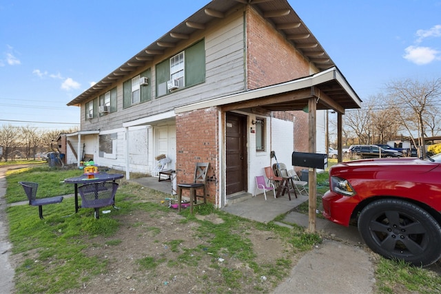 view of property exterior featuring cooling unit and brick siding