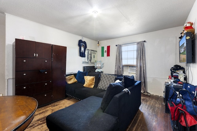 living area with cooling unit, wood-type flooring, and a textured ceiling