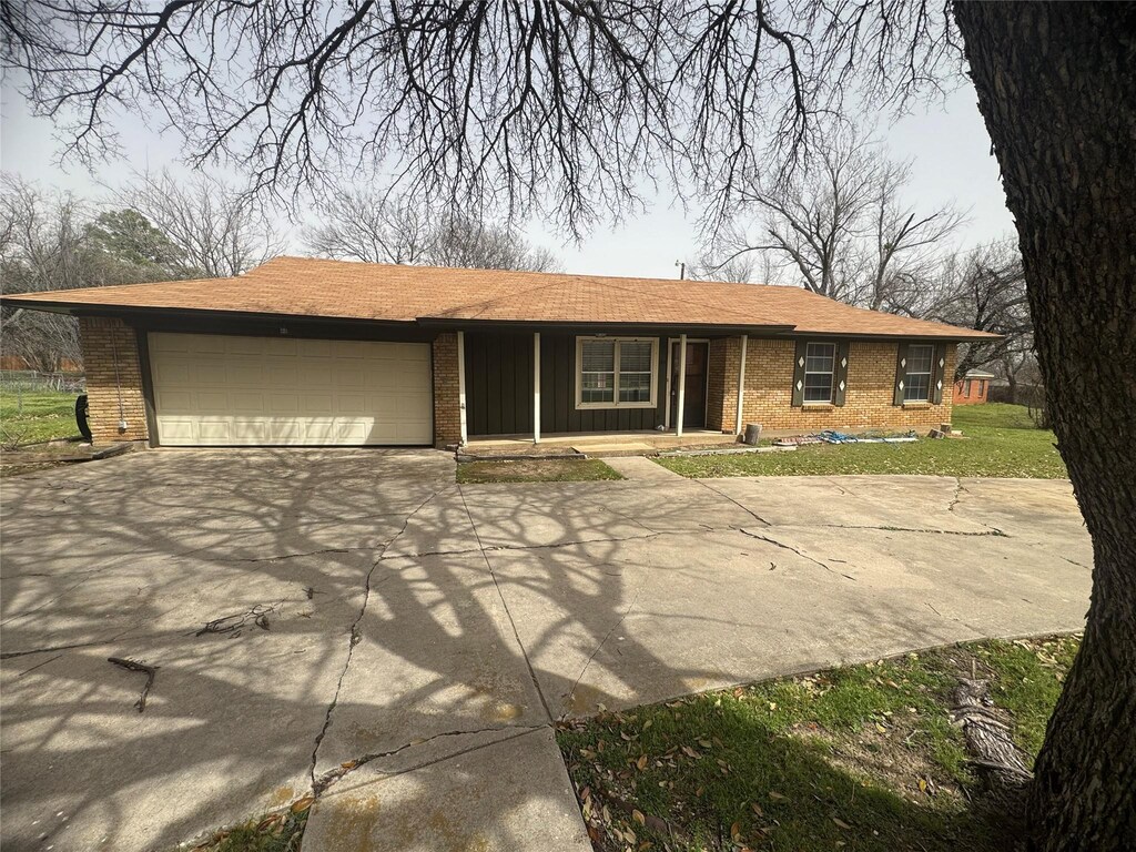 view of front facade with brick siding, an attached garage, concrete driveway, and a porch