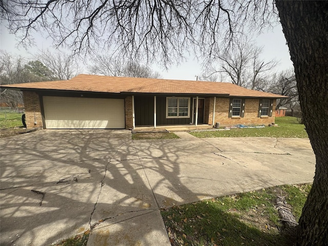 view of front facade with brick siding, an attached garage, concrete driveway, and a porch