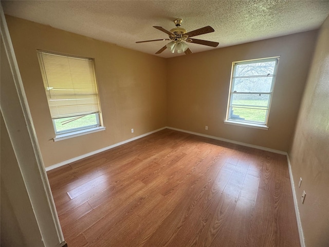 unfurnished room featuring light wood-style flooring, a ceiling fan, and baseboards