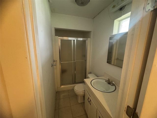 bathroom featuring tile patterned flooring, a shower stall, toilet, and vanity