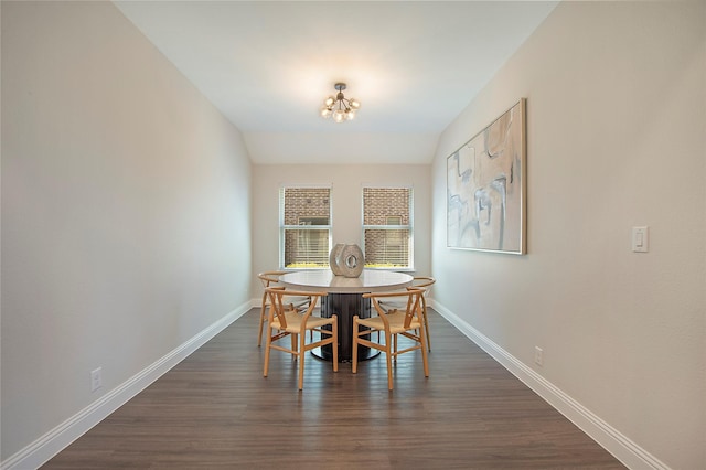 dining area featuring dark wood finished floors, an inviting chandelier, and baseboards