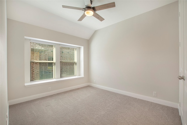 carpeted spare room with lofted ceiling, a ceiling fan, and baseboards