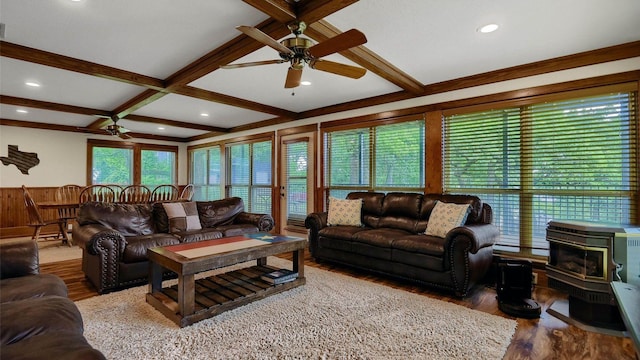 living area featuring beamed ceiling, a ceiling fan, coffered ceiling, wood finished floors, and a wood stove