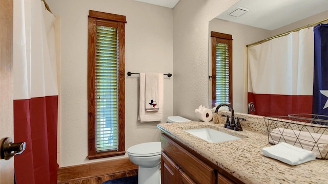 bathroom featuring toilet, vanity, a shower with shower curtain, and a textured wall