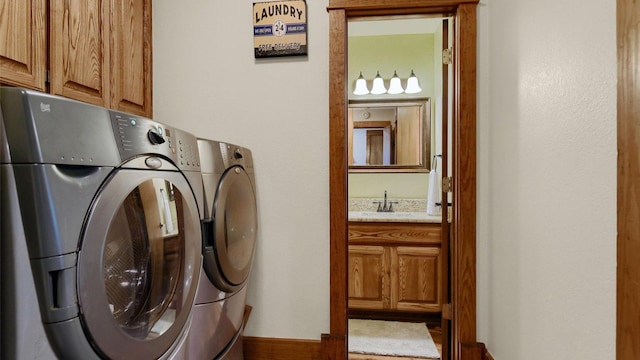 washroom with cabinet space, separate washer and dryer, and a sink