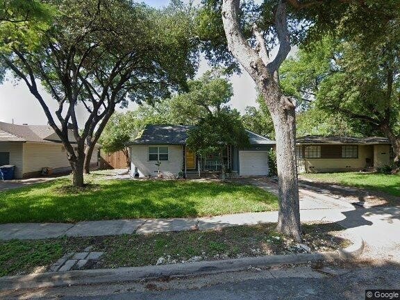 ranch-style house with a front yard and a garage