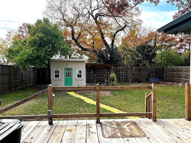 wooden deck featuring an outbuilding, a yard, and a fenced backyard