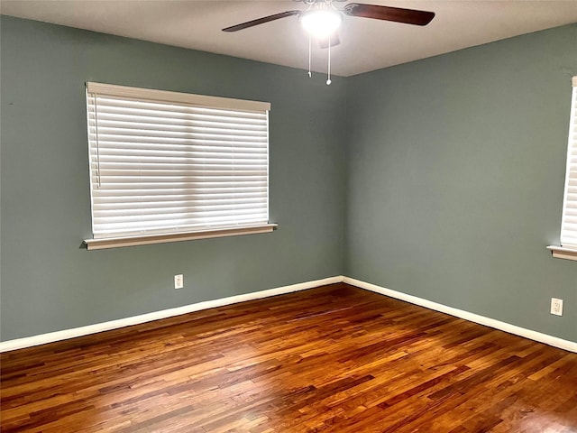 spare room featuring a ceiling fan, wood finished floors, and baseboards