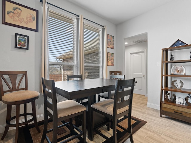 dining space with visible vents, baseboards, and light wood-style flooring