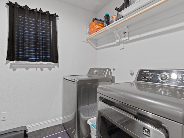 washroom with laundry area, washing machine and dryer, and baseboards