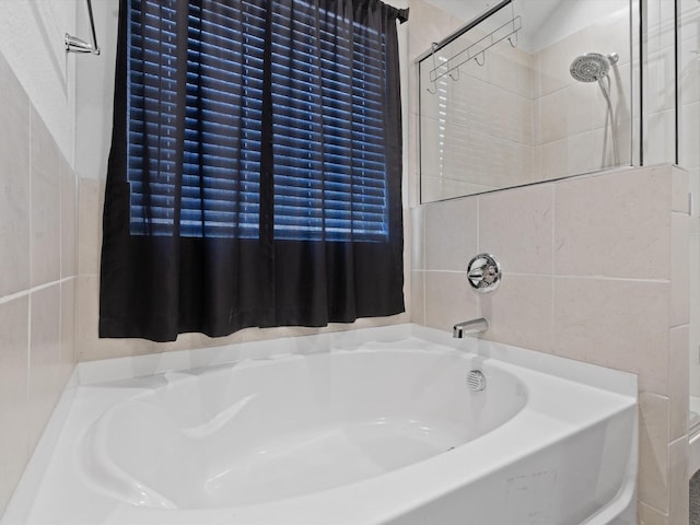 full bath with a bath and tile walls