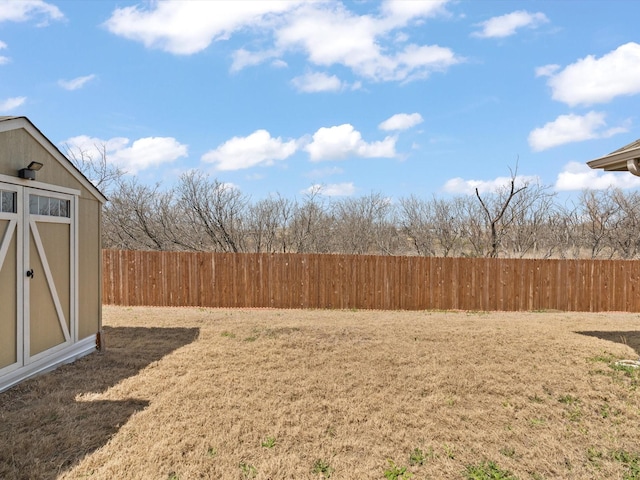 view of yard with an outbuilding, a shed, and fence